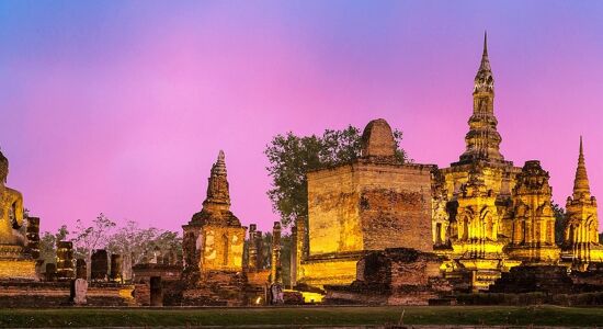 Iconic Buddha statues in Sukhothai for a vibrant Sukhothai Tours banner with Legend Travel Group.